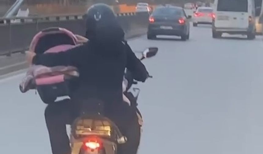 Bursa'da motosiklet üzerinde bebeği pusetiyle taşıdı